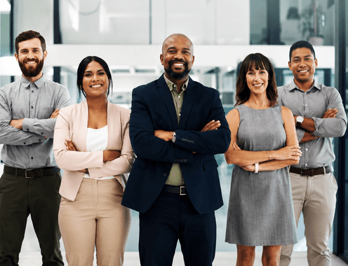 A diverse group of five smiling professionals standing together with arms crossed
